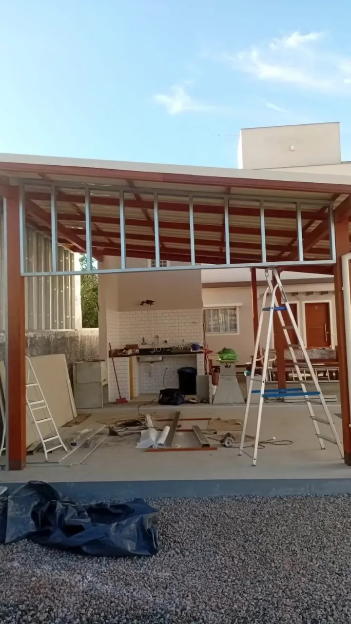 Estrutura de steel frame montada entre os pilares e vigas do pergolado de madeira