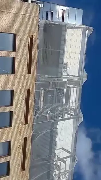 Fachada do prédio com a área em steel frame protegida por tela