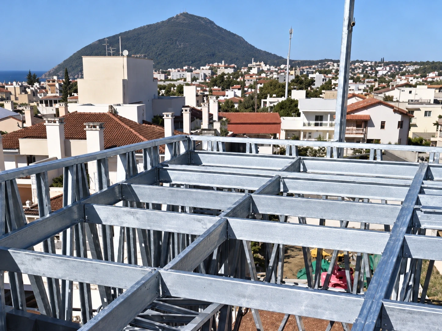 Grelha de steel frame em aço galvanizado na cobertura de um prédio, com o morro e a cidade de Florianópolis ao fundo