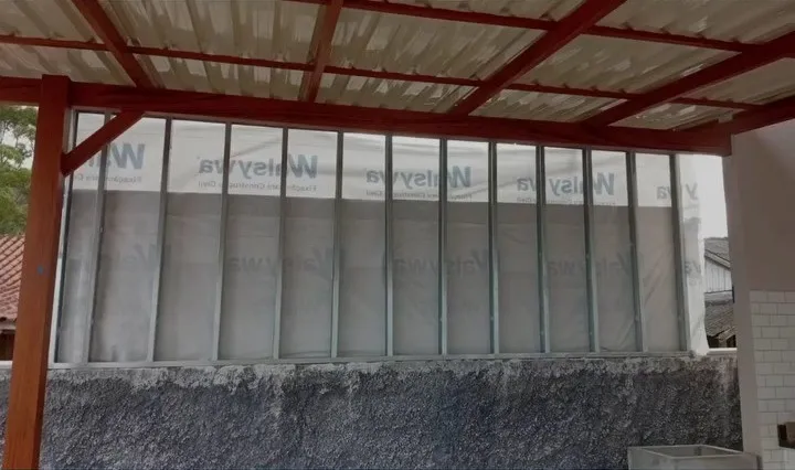 Montantes de steel frame com membrana hidrófuga vistos por baixo do pergolado