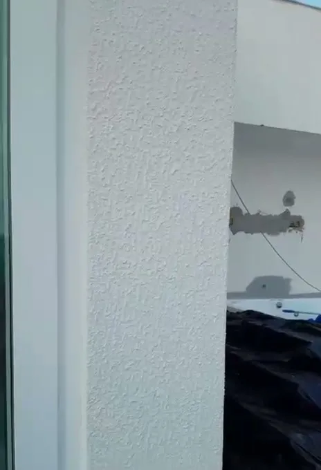 Pilar com textura recebendo pintura na fachada da casa