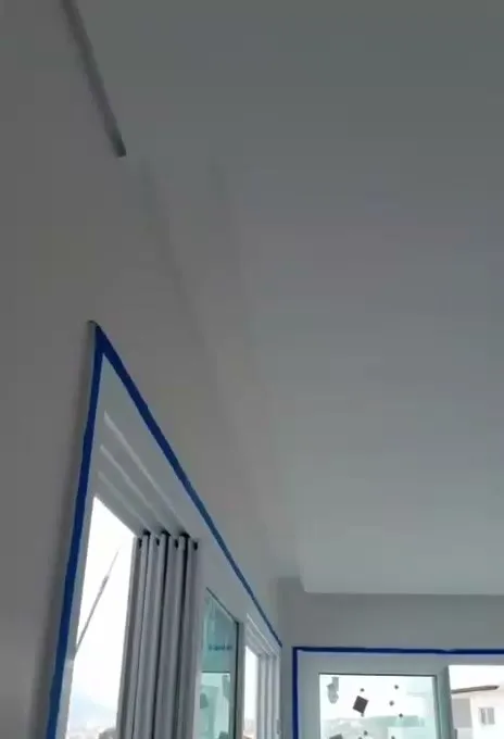 Forro pintado no encontro com a esquadria protegida por fita azul