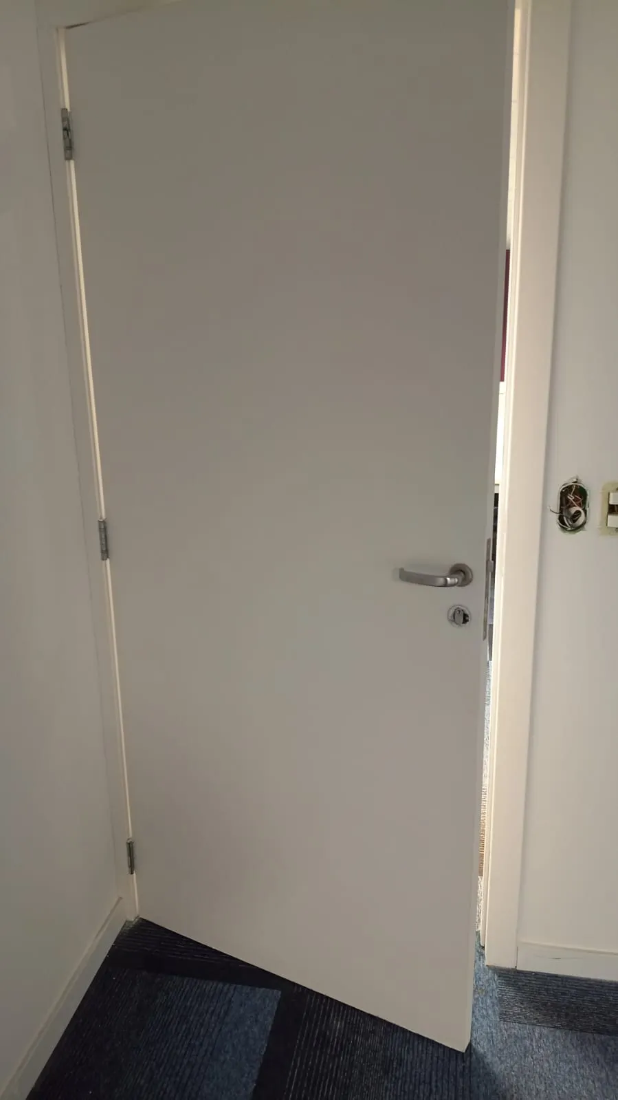 Porta acústica pintada de branco no acesso ao estúdio