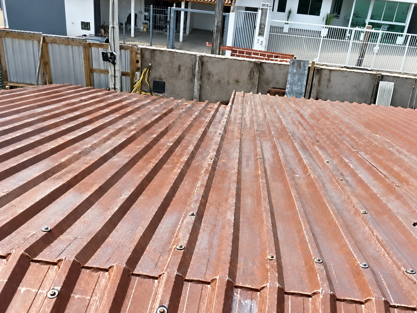 Telhado de telha metálica trapezoidal com parafusos de fixação e sobreposição entre as telhas em Florianópolis