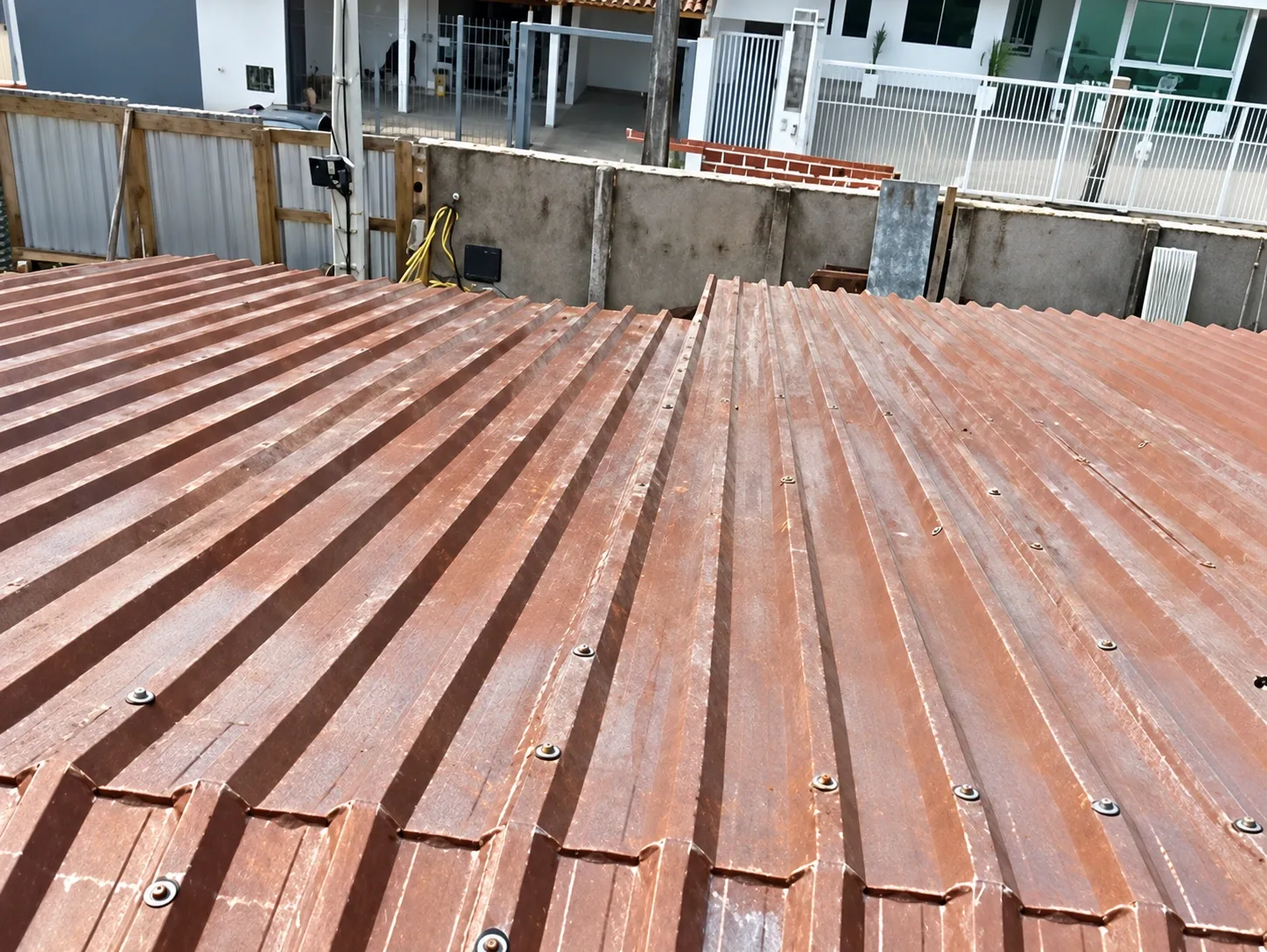 Telhado de telha metálica trapezoidal com parafusos de fixação e sobreposição entre as telhas em Florianópolis