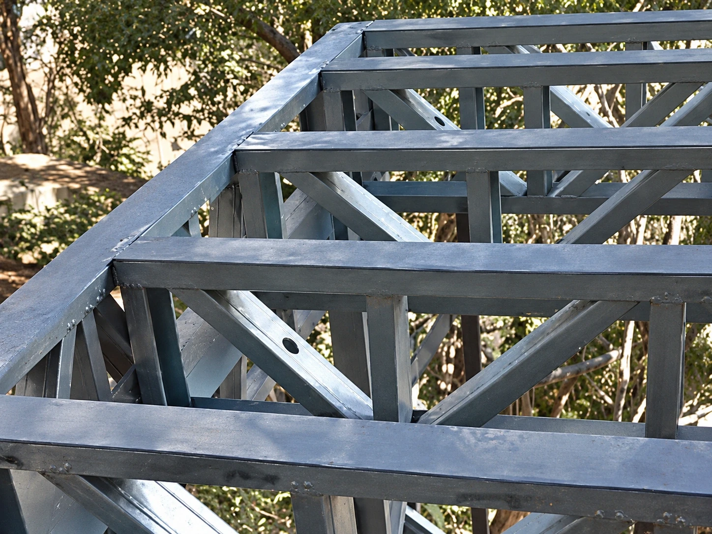 Vigas treliçadas de steel frame em aço galvanizado montadas para piso elevado em terreno com mata em Florianópolis